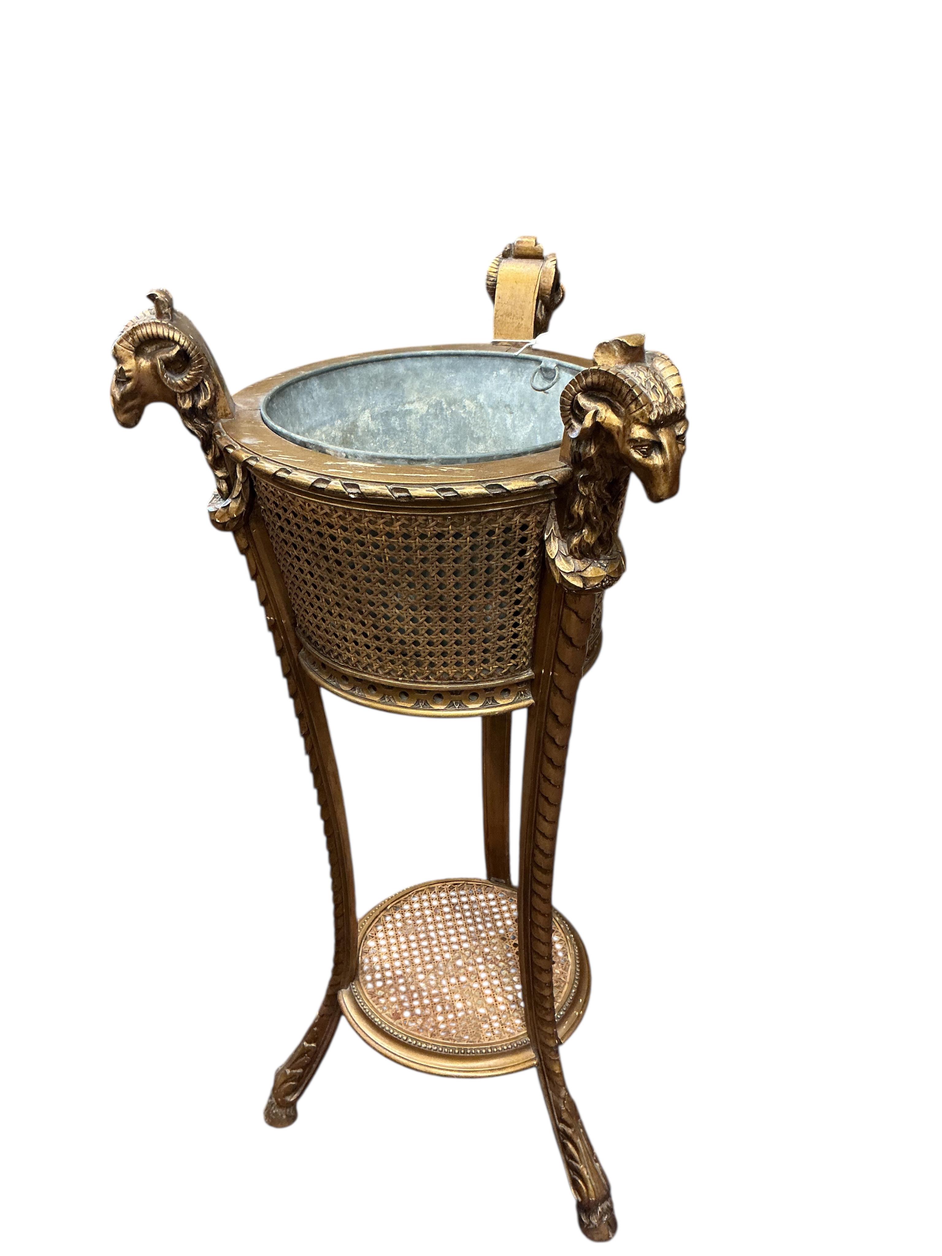 A Victorian style caned giltwood jardiniere with ram's head finials, height 99cm